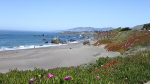Una playa con una vista despejada del océano y montañas distantes.