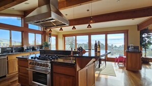 Una cocina amplia con una isla grande, armarios de madera y vistas al exterior.