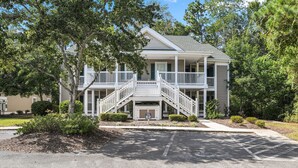 A two-story house with a front porch, a staircase, and a mailbox.