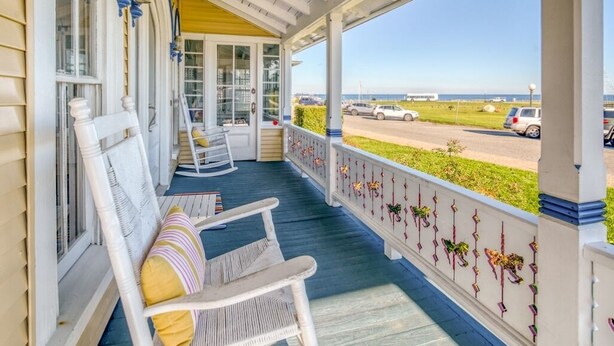 A covered porch with rocking chairs and a view of the beach. - "The Carousel House" - Ocean Park - Featured in New York Times (Oak Bluffs)