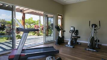 A home gym with a treadmill, elliptical, and stationary bike.
