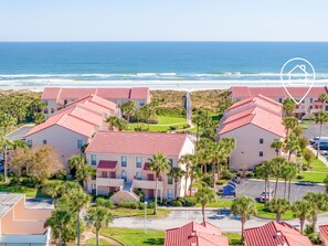 A coastal hotel with red-tiled roofs, multiple floors, and a view of the ocean. - OCEANFRONT 2 bed/2.5 bath Townhouse! Pool & Tennis (St Augustine)