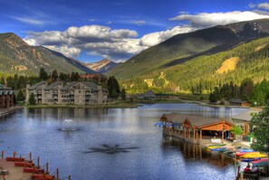 Un hôtel situé au bord d’un lac, doté d’un quai, composé de plusieurs étages et offrant une vue sur les montagnes.