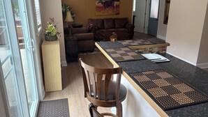 Ein modernes Wohnzimmer mit einer Couch, einem Couchtisch und einem Essbereich mit einer Bar.