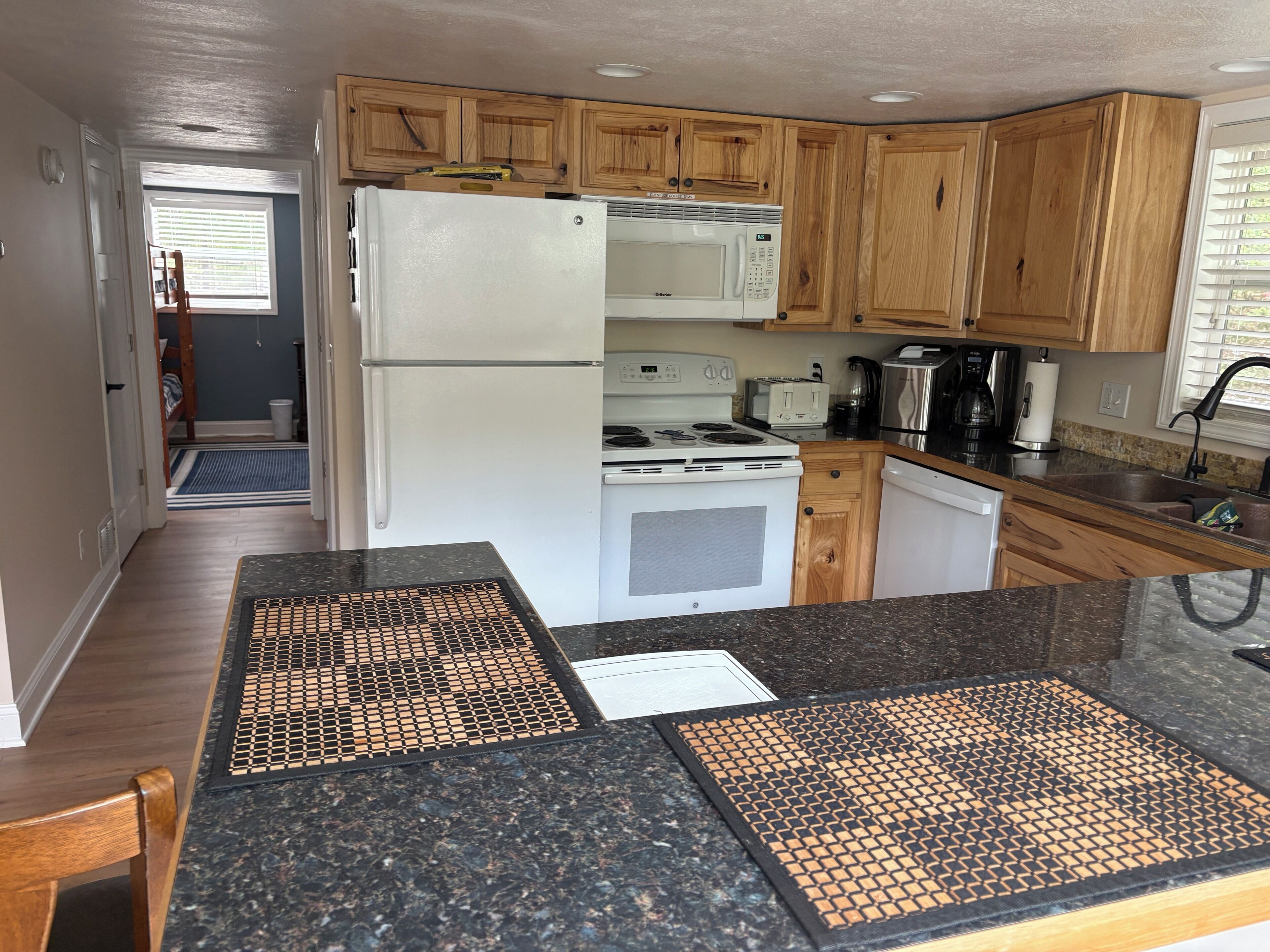 A kitchen with wooden cabinets, a white refrigerator, a stove, and a microwave.