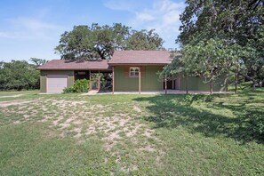 A single-story house with a garage, a covered porch, and a small front yard. - Lambert Park | Cozy 2BR Near Bandera Honky-Tonks (Bandera)