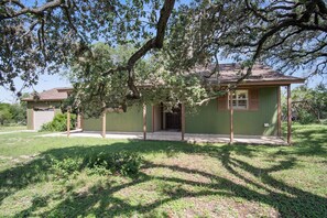 A single-story house with a covered porch, a garage, and a lawn.
