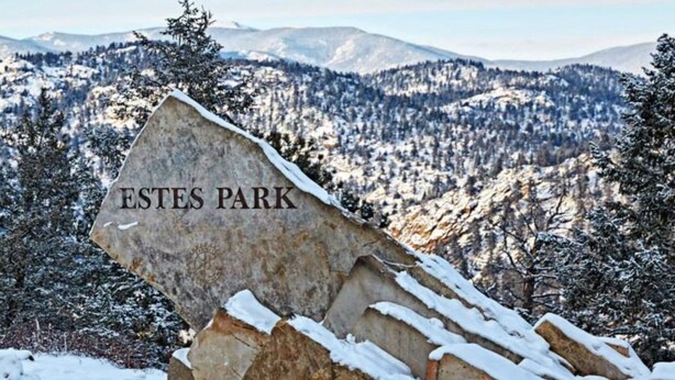 A snow-covered mountain with a large rock labeled "ESTES PARK" in the foreground.