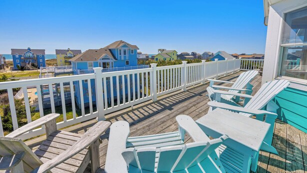 A wooden deck with white railings and turquoise Adirondack chairs. - Oceanview Dog Friendly w/ Private Pool, Hot Tub, Wet Bar. Shore Beats Workin' (Frisco)