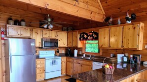 A wooden cabin kitchen with a stainless steel refrigerator, microwave, stove, and sink. - 'Endless View' from the Top of Sunrock Mountain (Blue Ridge)