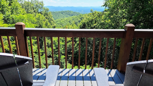A wooden deck with two Adirondack chairs facing a lush, green forested landscape. - 'Endless View' from the Top of Sunrock Mountain (Blue Ridge)
