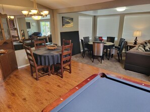 A dining area with a pool table, wooden chairs, and a chandelier. - Family Gatherings, Pool Table, Ping Pong, Hot Tub Fun!! (San Diego)