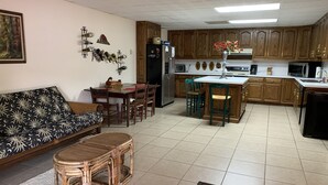 Um espaço compacto com sofá, mesa de jantar e cozinha.