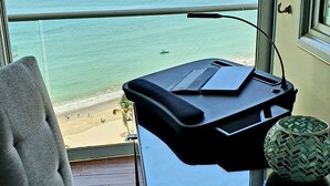 Ein Balkon mit Meerblick, ein Stuhl und ein kleiner Tisch mit einer dekorativen Schale.