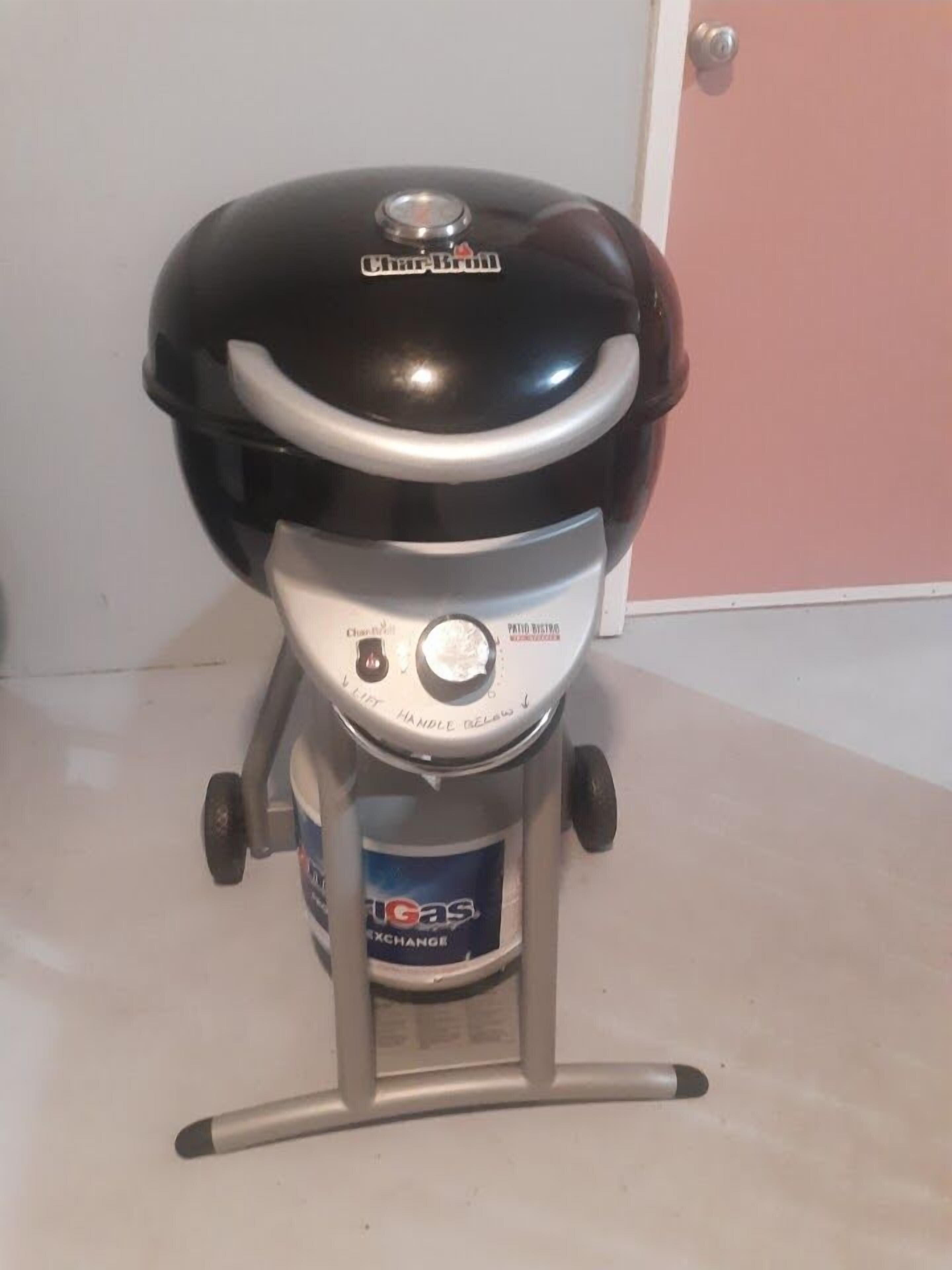 A portable charcoal grill with a control panel and a gas exchange label.
