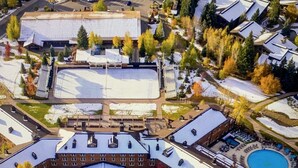 An aerial view of a hotel with a central courtyard, multiple buildings, and a swimming pool.