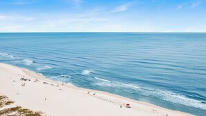 A beach with a clear sky and calm sea.