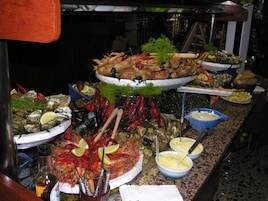 Buffet variado com pratos de frutos do mar, incluindo camarão, ostras e lagosta.
