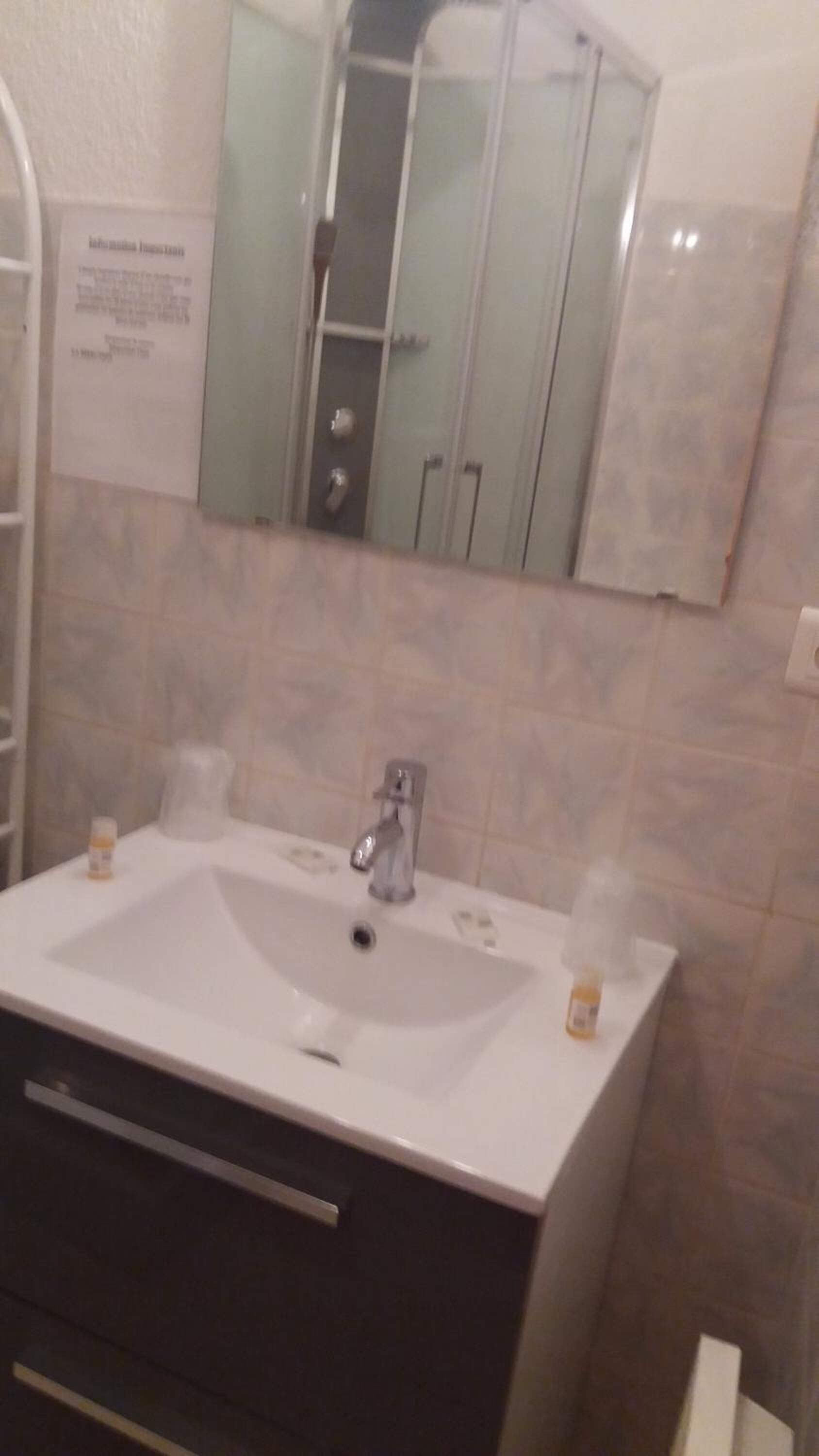 A bathroom with a white sink, a mirror, and a cabinet.