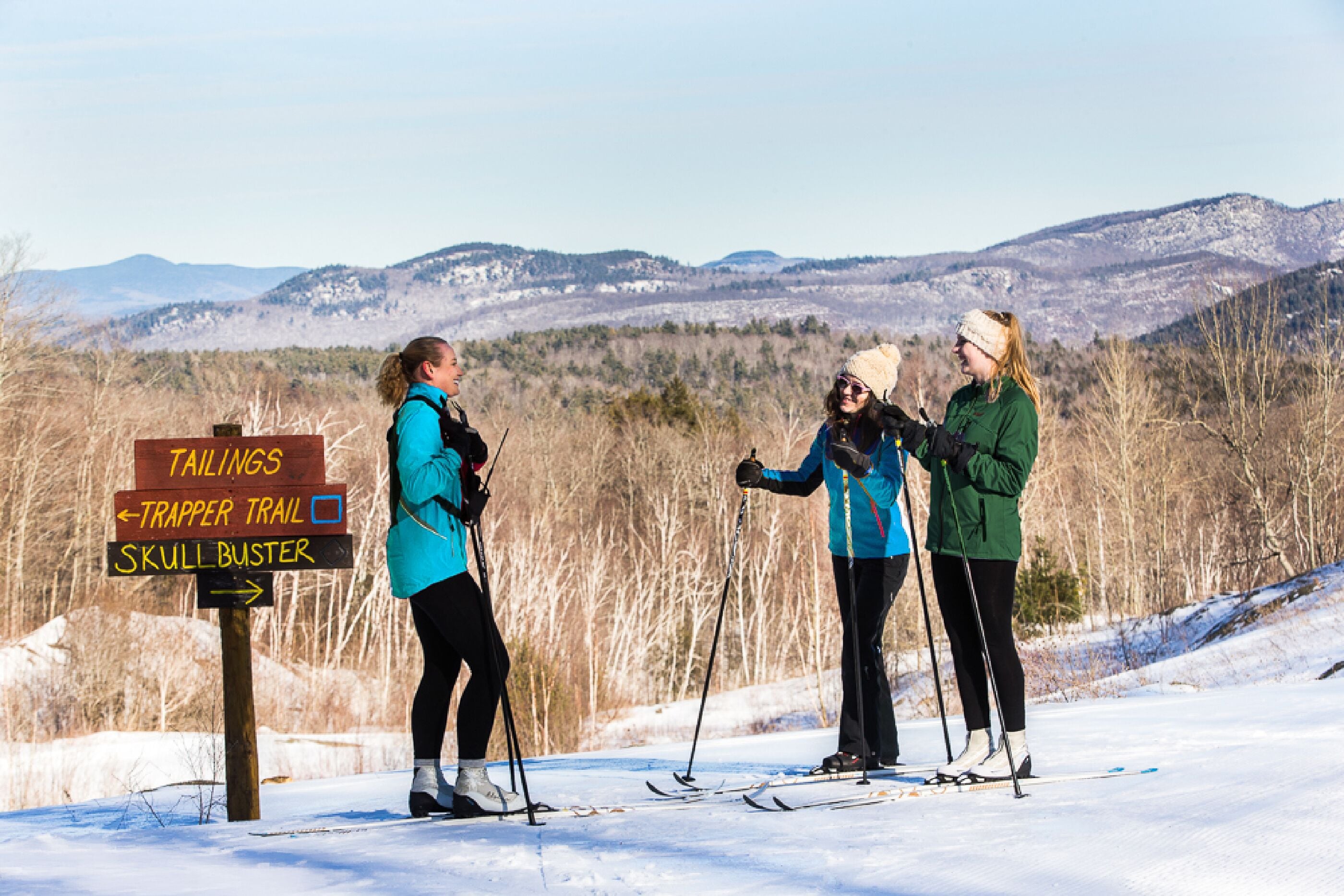 A signpost with directions to Tailings, Trapper Trail, and Skull Buster.