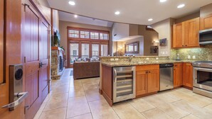 Una cocina moderna con gabinetes de madera, encimera de granito y electrodomésticos de acero inoxidable.