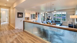 A spacious living area with a modern kitchen, a dining area, and a balcony with a view.