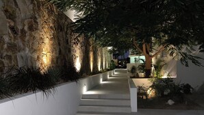 A modern outdoor pathway with steps leading to a building, surrounded by greenery and illuminated by ambient lighting. - Luxury w/ Breathtaking Views! 10-minute walk to the marina - Cascadas 302 (Cabo San Lucas)