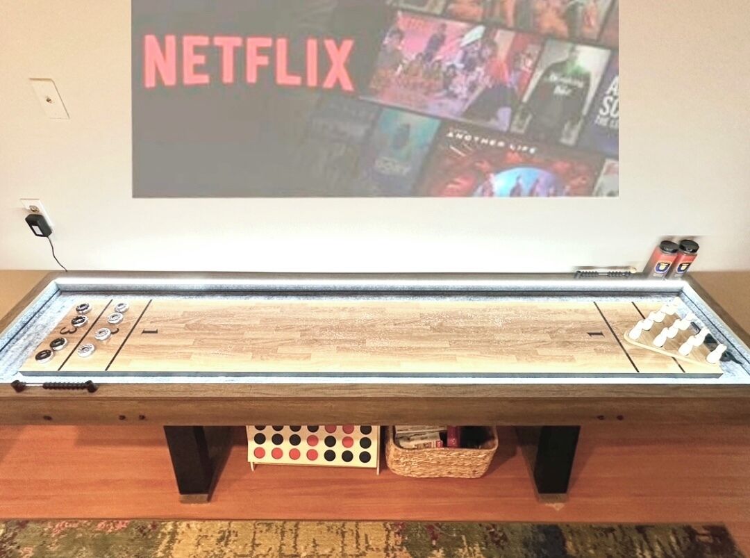 A wooden table with a projector screen displaying the Netflix logo.