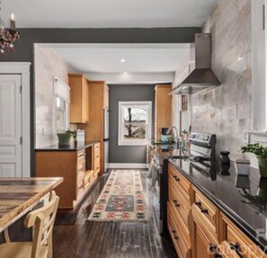 Una cocina moderna con armarios de madera, una isla central y una alfombra estampada.