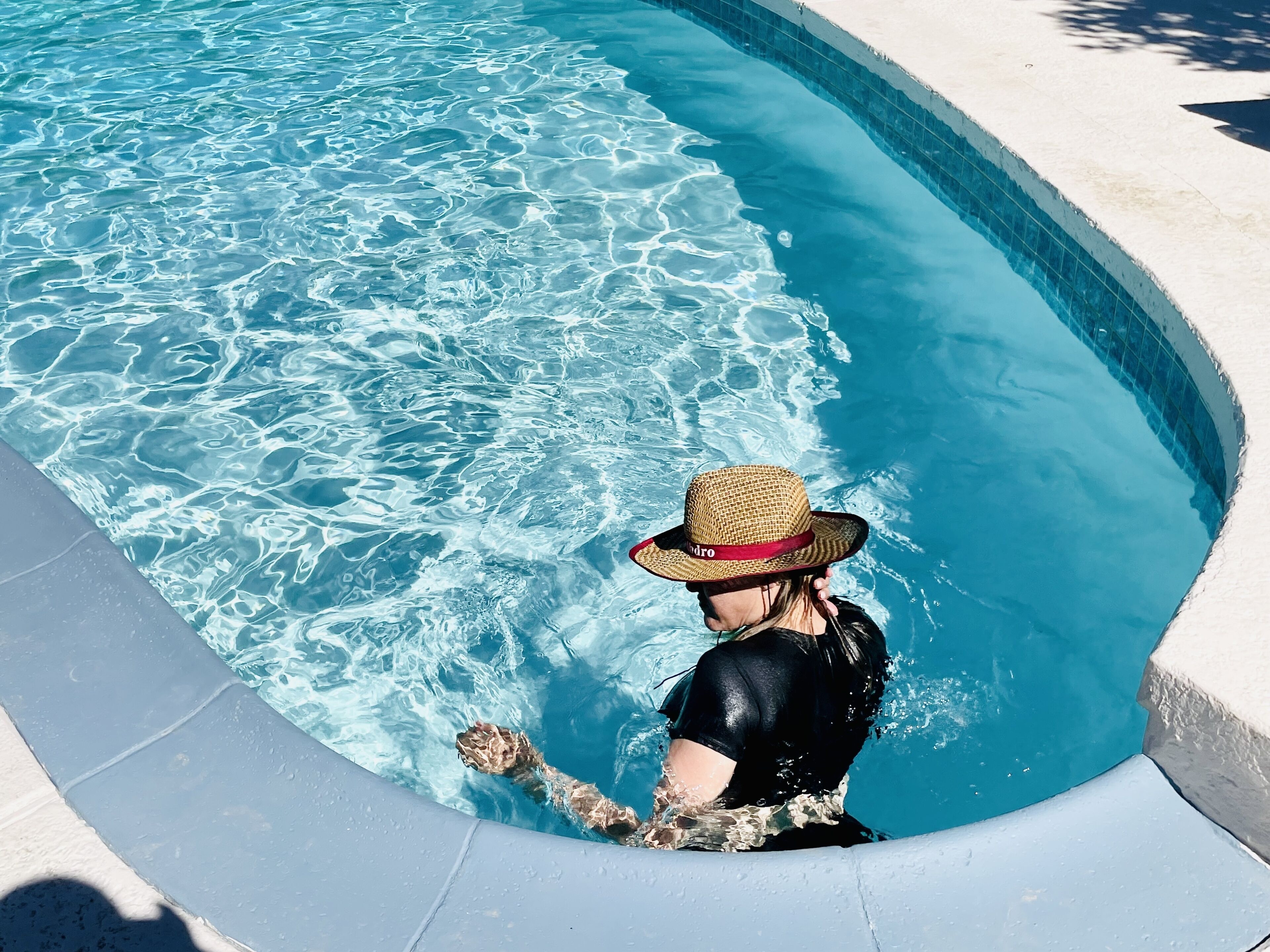 Una persona en una piscina llevando un sombrero.