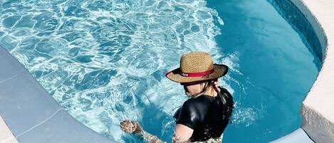 Una persona en una piscina llevando un sombrero.