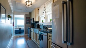 Cocina moderna con electrodomésticos de acero inoxidable, una ventana con plantas y vistas al área de comedor.
