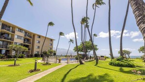 A hotel with multiple floors, a swimming pool, and palm trees. - Oceanview Kanai A Nalu 316 Great Views Split AC Pool Great Value (Wailuku)