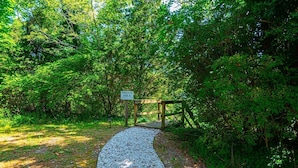 A gravel path leading to a wooden dock with a sign reading "PRIVATE DOCK".