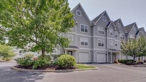 A row of townhouses with a central driveway and landscaped front yards.