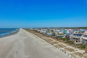 Stroll along the wide, sandy beach adjacent to charming houses with diverse architectural styles.