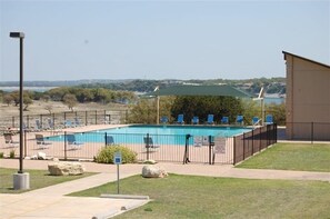 Relax by the pool surrounded by lush greenery and comfortable lounge chairs.