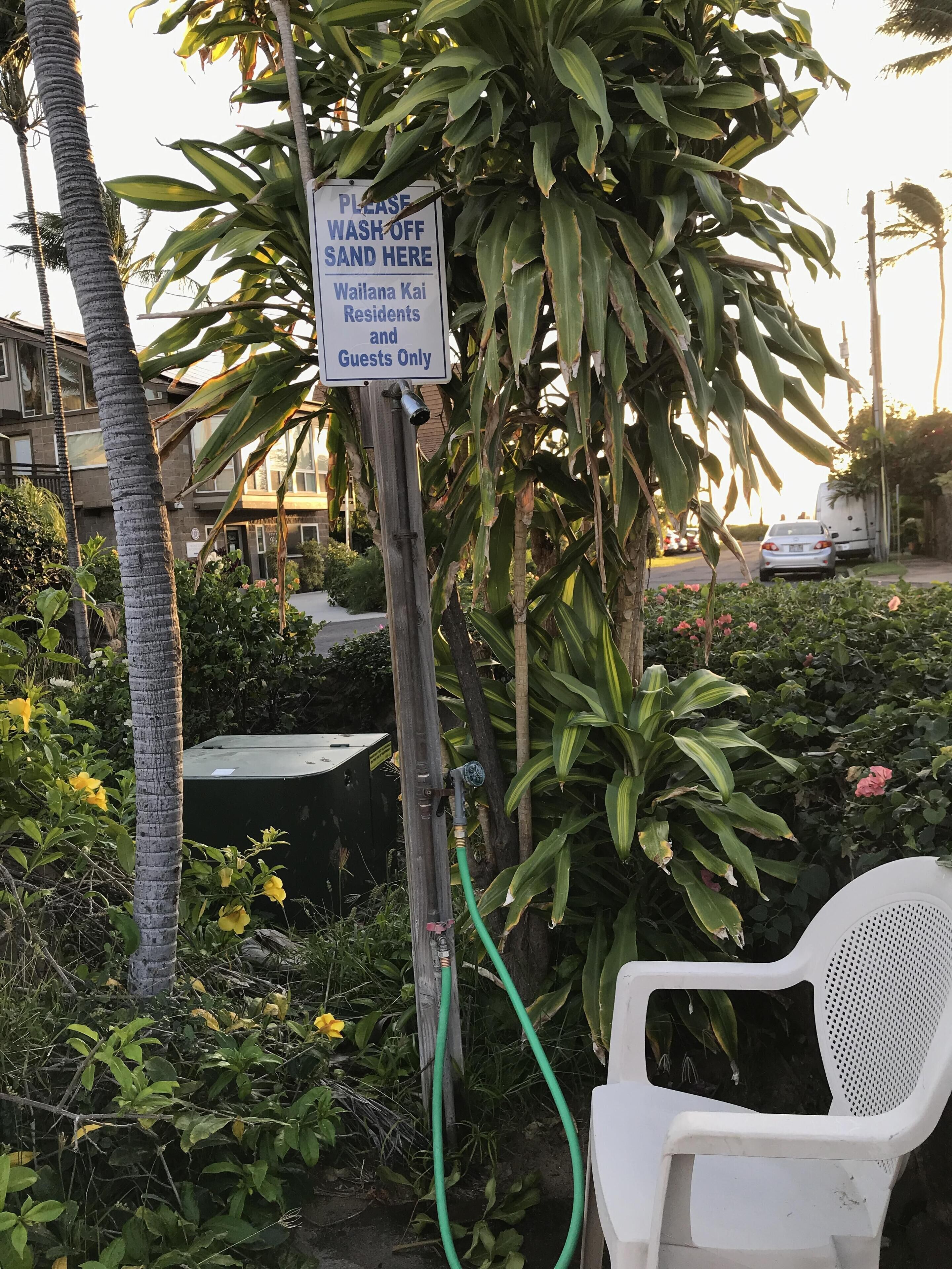 Letrero que indica lavar la arena en una ubicación específica para residentes e invitados del Wailana Kai.
