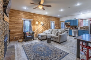 A spacious living area with a sofa, a coffee table, a rug, and a ceiling fan. - Escape to The Red Barn! Private Retreat on 8 acres w/Firepit & Stocked Pond! (Peebles)
