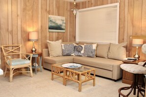 Relax in this inviting living room with a sofa, coffee table, and wicker chair.