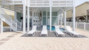 Una piscina exterior cubierta con tumbonas, una escalera y una zona de terraza.