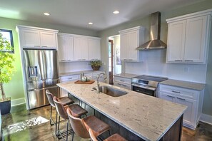 Enjoy cooking in this well-equipped kitchen with a large island, stainless steel appliances, and ample counter space.