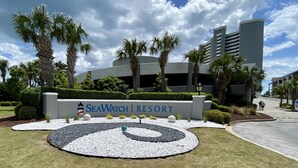 Letrero de un resort con un diseño circular y palmeras.