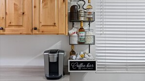 Eine Küche mit Holzausstattung, einer Kaffeemaschine und einer Kaffeebar-Beschilderung.