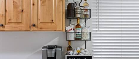 A kitchen with wooden cabinets, a coffee machine, and a coffee bar sign.