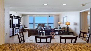 Une chambre d’hôtel avec un coin repas, une télévision et une vue sur l’océan.
