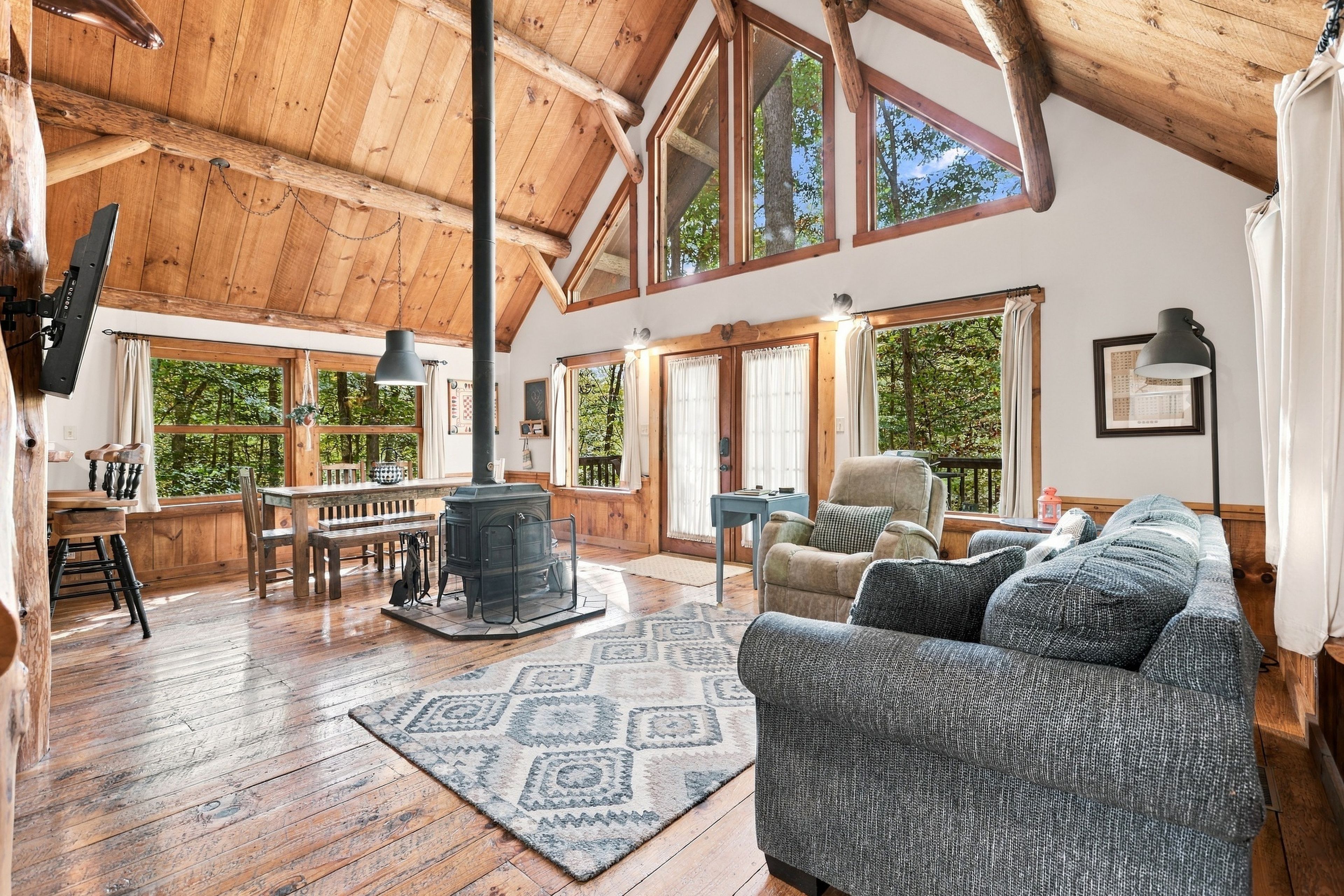 A spacious loft with high ceilings, large windows, a fireplace, and a cozy seating area.