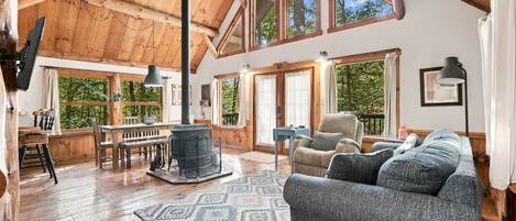 A spacious loft with high ceilings, large windows, a fireplace, and a cozy seating area.
