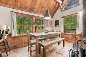 A rustic wooden interior with a large dining table, benches, and a hanging light fixture. - A couple's get-away in the woods. (Nelsonville)