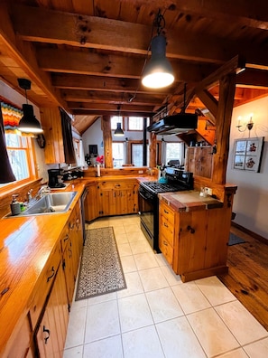 Een landelijke keuken met houten kastjes, een fornuis en een spoelbak.